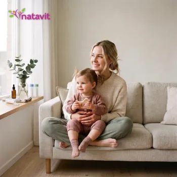 Konsultacja homeopatyczna dla dzieci – mama z maluchem na kanapie, obok granulki homeopatyczne i świeże zioła